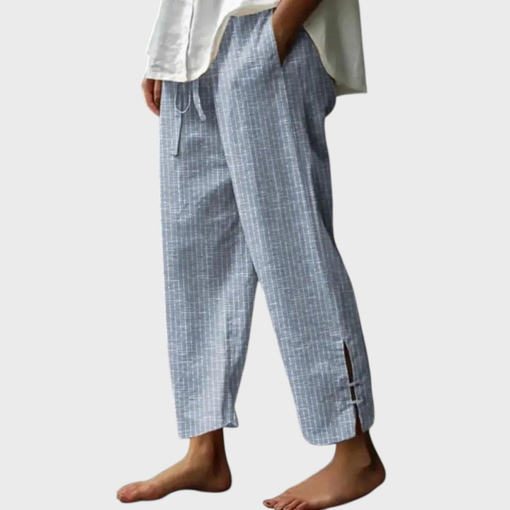 Calças Liselotte Salzburg Bellie em algodão azul com padrão riscado, cós com cordão e bainha com fenda lateral.