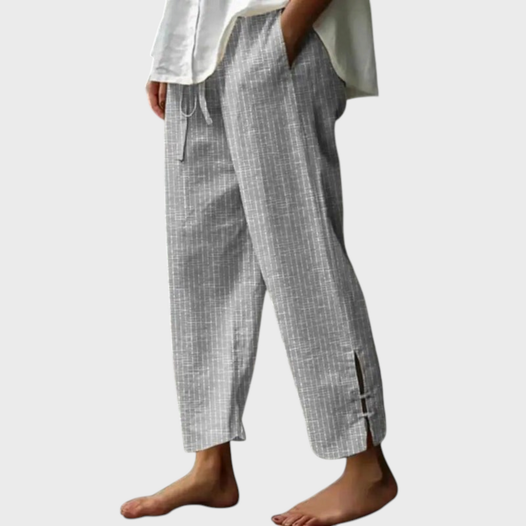 Calças Liselotte Salzburg cinzentas em algodão com padrão linear, cintura com cordão e bainha com detalhe de fenda.