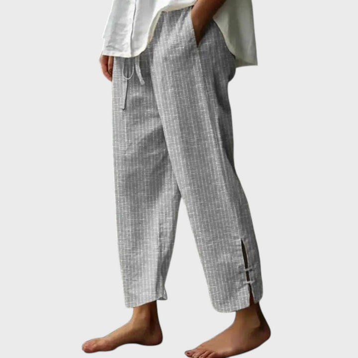 Calças Liselotte Salzburg cinzentas em algodão com padrão linear, cintura com cordão e bainha com detalhe de fenda.