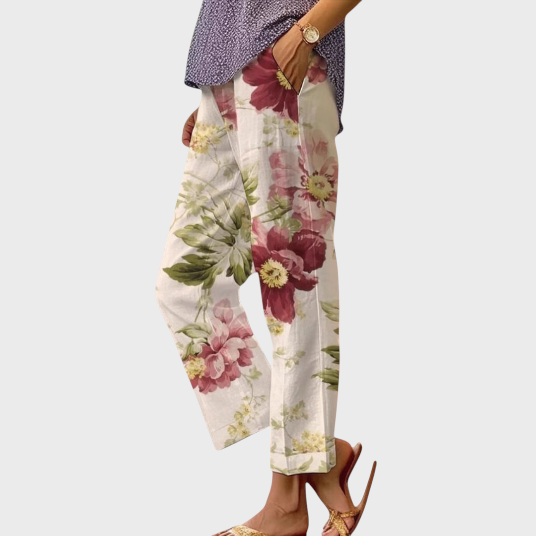 Calças Liselotte Salzburg com padrão floral em tons de rosa e verde, corte largo, cintura elástica e bolsos laterais.