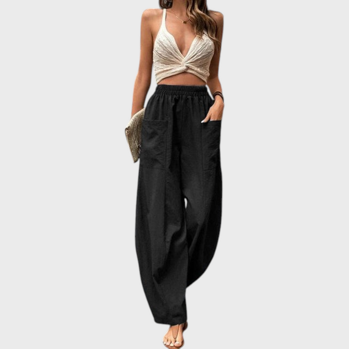 Calças pretas largas Liselotte Salzburg com cintura elástica, bolsos grandes e corte fluido estilo boho.