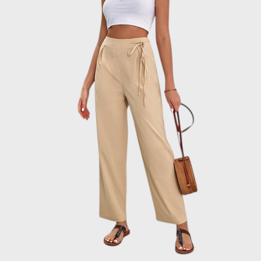 Calças bege de cintura subida com perna larga e detalhe de laço, da marca Liselotte Salzburg, estilo casual elegante.
