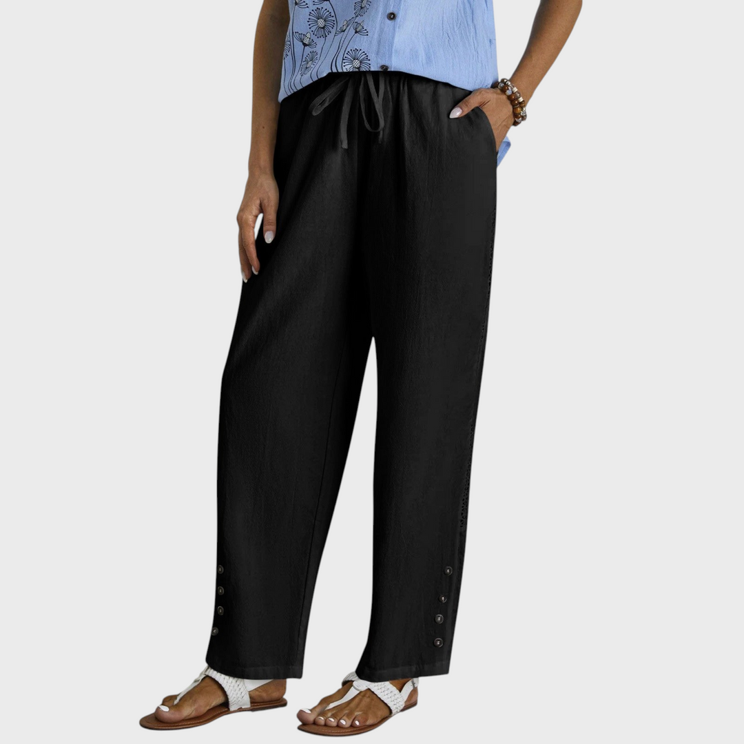 Calças pretas Liselotte Salzburg com cordão na cintura e detalhes de botões na bainha, estilo casual e elegante.
