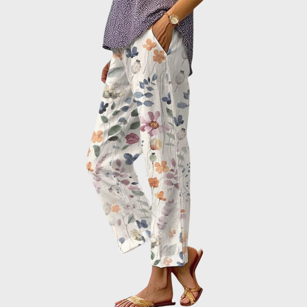 Calças casuais Liselotte Salzburg com padrão floral colorido, corte largo, cintura elástica e bolsos laterais profundos.