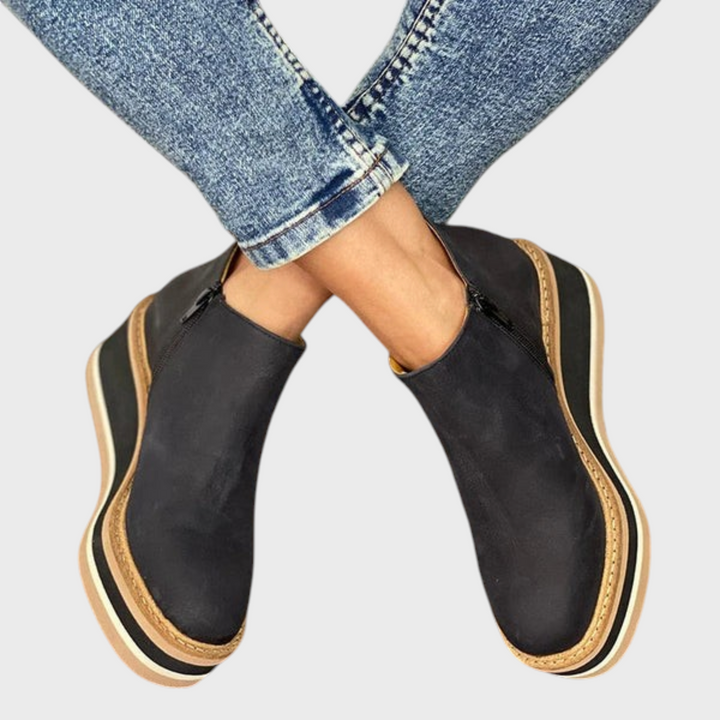 Stiefeletten Cara de Liselotte Salzburg em preto com sola plataforma listrada e fecho lateral, usadas com jeans.