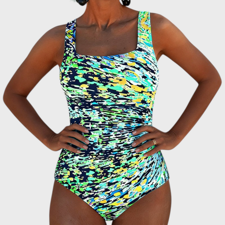 Badeanzug Marga da Liselotte Salzburg com padrão abstrato colorido em tons de azul, verde e amarelo, decote quadrado.
